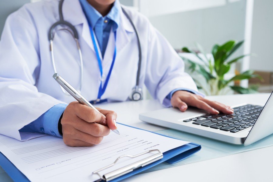 General physician consulting a patient and reviewing medical records